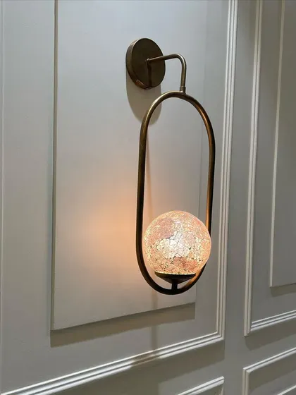 We love designing custom elements, like this wall light with a globe made of stained glass mosaic. It casts a unique, warm light and acts as a piece of art on the wall.