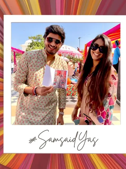 A guest proudly showing off their instant photo print. It's a tangible memory from the #SamsaidYas wedding that they can take home immediately.