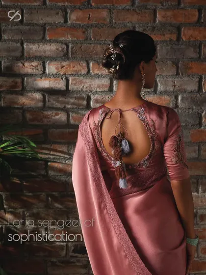 For a sangeet of sophistication, this dusty rose organza saree with a detailed keyhole back blouse is the perfect choice to dance with grace and dress with grandeur.