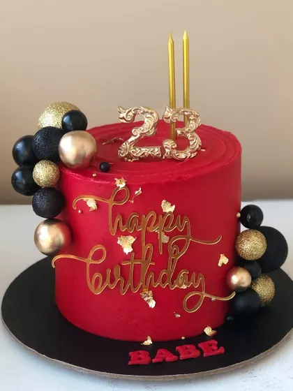 A striking red, black, and gold cake for a 23rd birthday. The bold colors make a real statement.