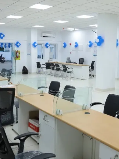 An open-plan office setup for the Ashok Leyland factory, featuring low glass partitions on the desks. This maintains an open line of sight for easy communication while providing a degree of separation for focused work.