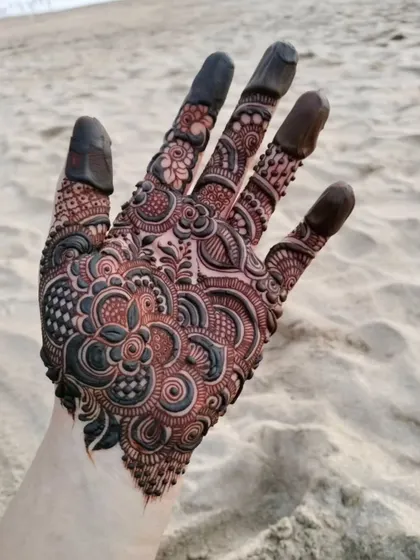 A beautiful and intricate design captured at the beach. The fine details and shading are still visible even with the dark paste.