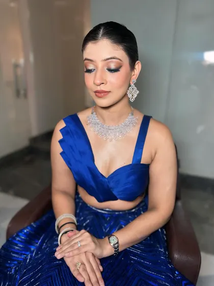 A bold and beautiful look for a cocktail party. The focus is on a dramatic smokey eye, created to complement her stunning royal blue lehenga.