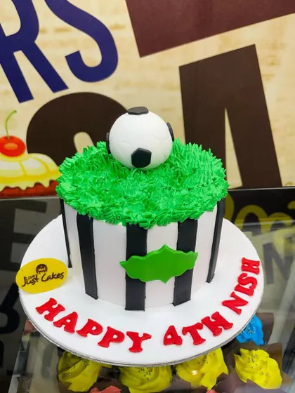 A 1.5kg football cake with a ball on a field of green icing.