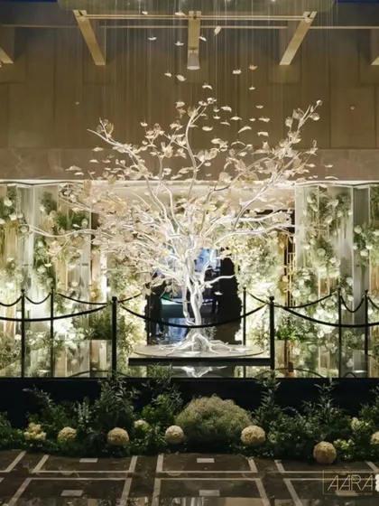 A magnificent crystal tree stands as the centerpiece, surrounded by a forest of white florals and lush greenery. This installation was designed to be a celebration of understated beauty and luxurious simplicity.