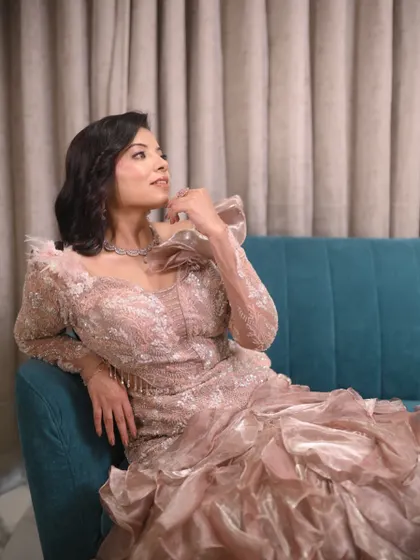 A thoughtful pose in a magnificent gown. The detailed lace sleeves and dramatic ruffled skirt of this gown create a look of pure opulence.