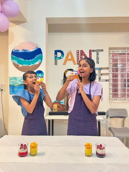 These two sisters are playfully pretending to eat their mango dessert candles. It's all about having fun!