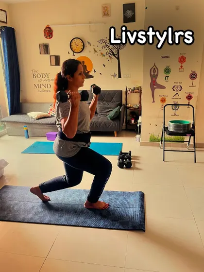 A client performs a lunge with bicep curls, a compound move that efficiently works both the upper and lower body.