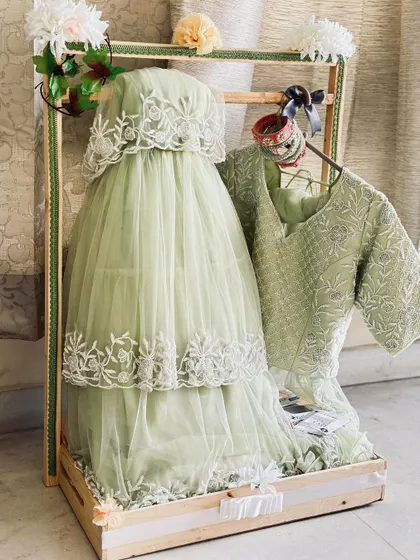 A beautifully packed baby outfit in a pinewood tray, part of a larger baby shower trousseau collection.