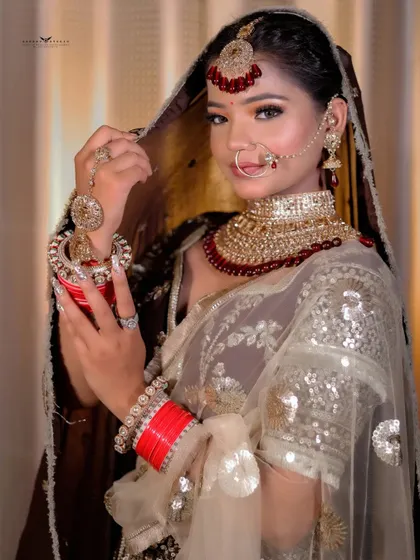 A classic bridal pose, with the bride holding a decorative pot (kalash). This adds a traditional and auspicious element to the photoshoot.