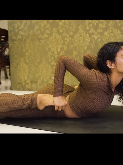 A deep stretch in Bhekasana (Frog Pose), a powerful posture for opening the quadriceps and hip flexors.
