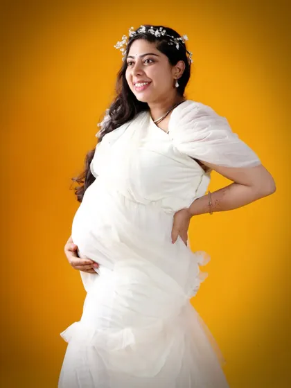 A joyful close-up of a mom-to-be in our white maternity gown. The soft fabric and elegant design are perfect for capturing the happiness and anticipation of pregnancy.
