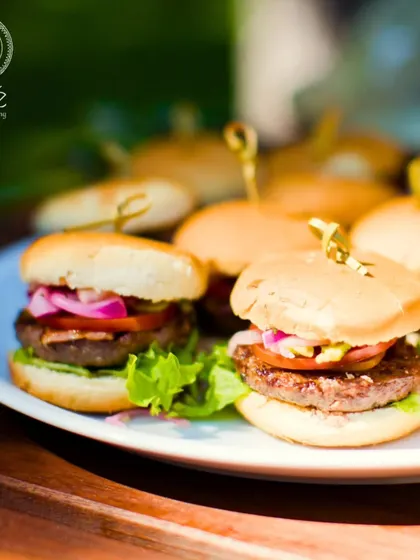 A plate of delicious mini burgers, perfect as a hearty appetizer for any event. We use high-quality ingredients to create gourmet versions of classic comfort foods.