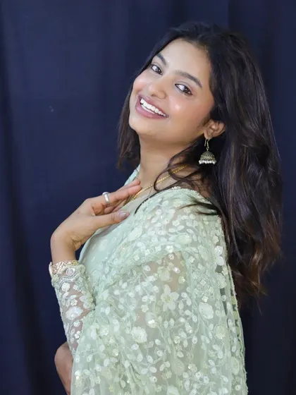 A smiling portrait of Sonu, her natural beauty shining in our elegant designer saree.