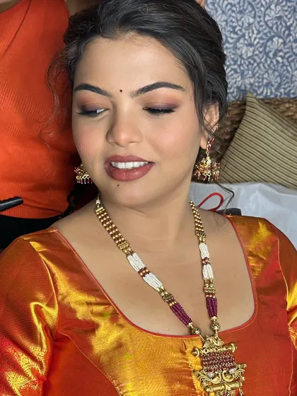 A close-up on the soft, smudged eye makeup and nude pink lips.
