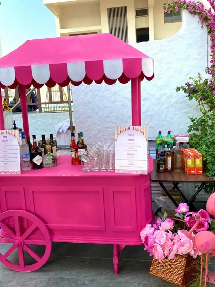 A fun, flamingo-pink bar cart, perfectly matching the vibrant theme of a poolside Haldi celebration.