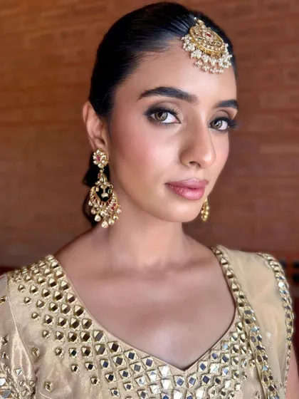 A beautiful front-facing shot highlighting the 'glow getter' makeup, with luminous skin and captivating eyes for a Sangeet.