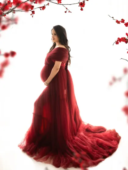 A striking profile shot against a clean white background. The red floral frame adds a pop of color and artistry to this beautiful maternity portrait.