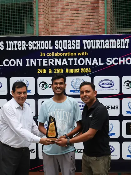 Presenting an award to a coach for his contribution to the sport. We believe in recognizing the efforts of everyone involved in the squash community.