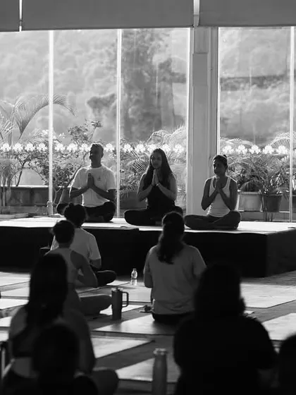 A black and white shot of our community in meditation during the International Yoga Day event. The practice continues to shape, heal, and connect us.
