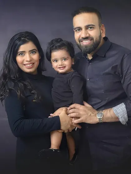 The best thing to hold onto in life is each other. A classic family portrait in matching black outfits. The simple, dark background really makes their happy faces shine.