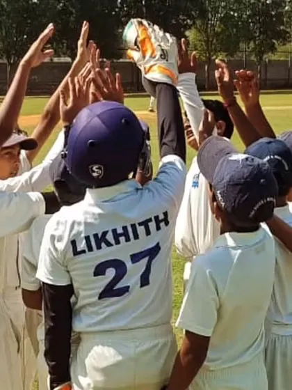 A team celebration in a huddle after taking a wicket during the Christmas Cup.