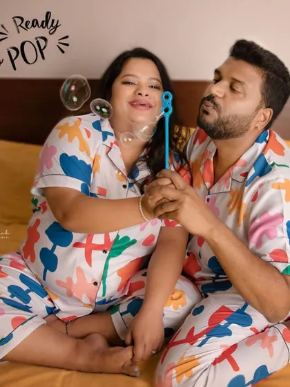 Ready to pop! This fun photo with bubbles adds a touch of whimsy to their pajama-themed maternity shoot, perfectly capturing their playful personalities.
