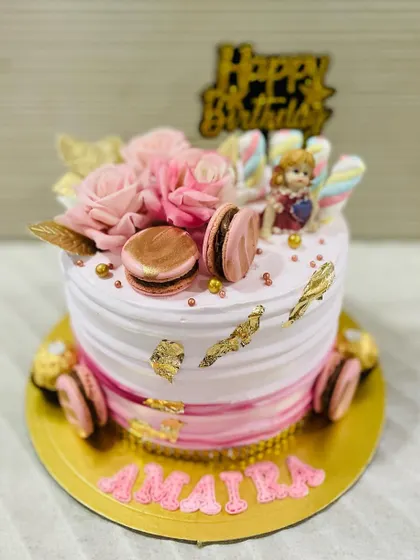 The finer things in life: a beautiful pink cake with gold leaf, macarons, and delicate pink roses.