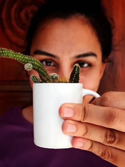 Peeking over a tiny coffee mug that I repurposed as a planter for this cute little cactus.