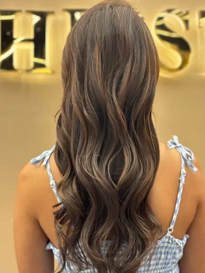 The back of long hair with a fresh color treatment, styled into beautiful, uniform waves that showcase the vibrant new hue.