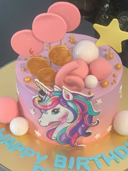 Another take on the popular unicorn theme. This purple cake features an edible unicorn print and is decorated with pink and white chocolate spheres.