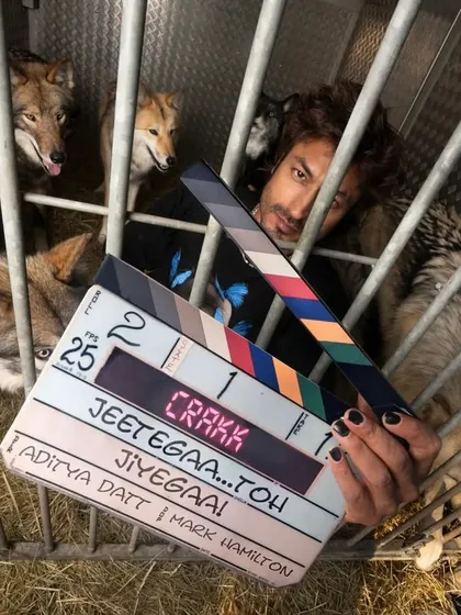 Vidyut Jammwal with the clapperboard in a cage with wolves for a thrilling scene in "Crakk". It was a unique challenge to design a costume that worked for this intense sequence.