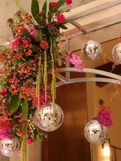 Detail of the floral arch, with mini disco balls and cascading flowers creating a sparkling, glamorous effect.
