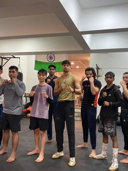 The kickboxing crew after a tough session with their coach. The smiles and strong stances show the camaraderie and confidence built on the mats.