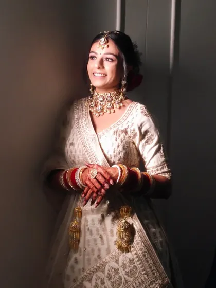 A beautiful candid photo of the bride smiling. The lighting highlights the glowing finish of her makeup.