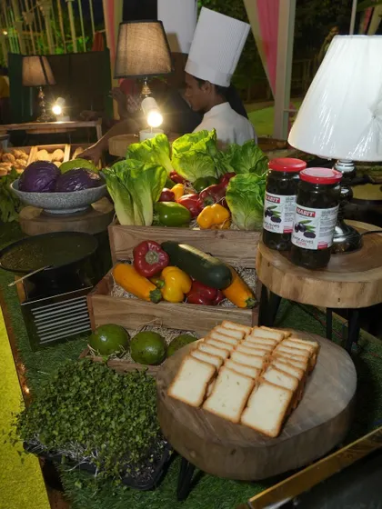 A nighttime view of our sandwich and salad bar. The station is beautifully lit and stocked with fresh produce like avocados, bell peppers, and lettuce, ready for guests to create their own custom sandwiches.