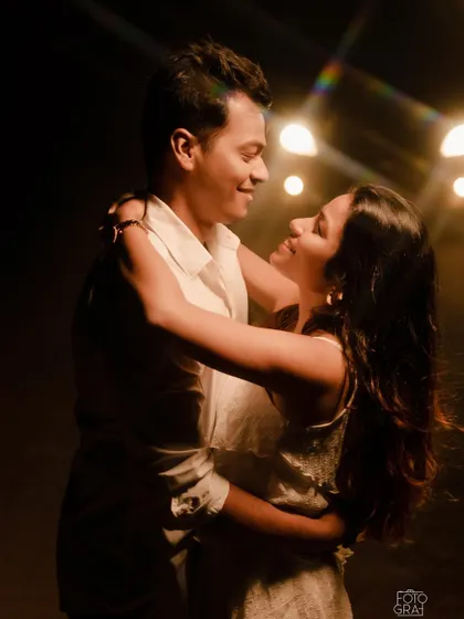 The same couple, now illuminated, sharing a dance in a warmly lit, intimate setting. Their smiles show their deep connection.