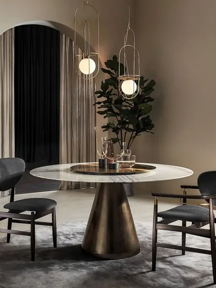 A stunning round dining table with a marble top and sculptural brass base, featured at a design event. This piece exemplifies our commitment to creating luxurious, statement furniture for the discerning client.