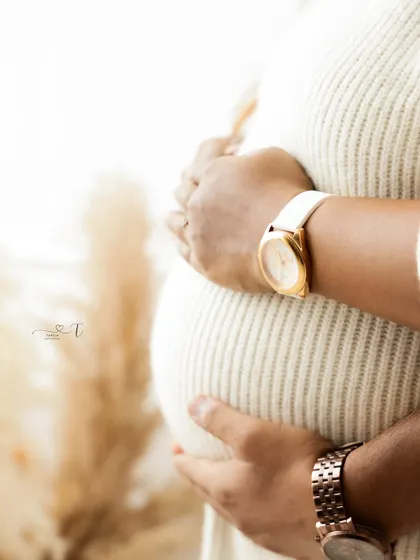 A close-up shot focusing on the couple's hands embracing the baby bump. This detailed shot beautifully symbolizes their connection and shared journey.