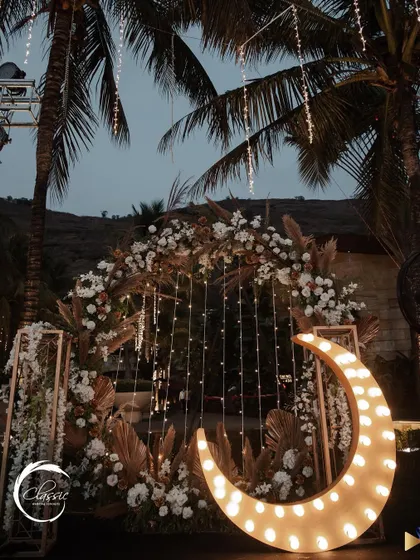 I designed this dreamy, boho-inspired photo booth with a large, lit-up crescent moon, pampas grass, and white florals. It was a huge hit and created the most magical photos.