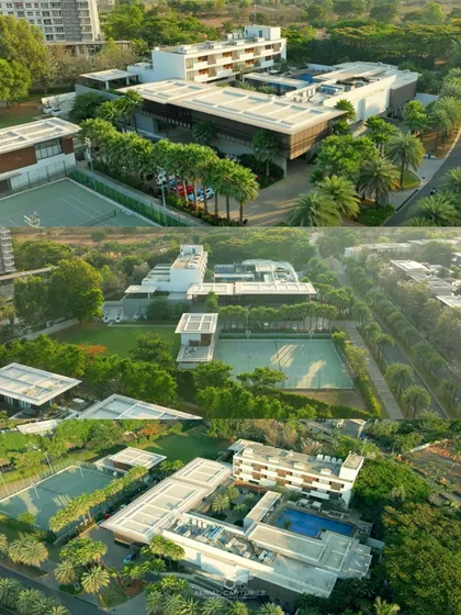 A wide aerial perspective of the BLVD CLUB, capturing its modern architecture, tennis courts, and swimming pool nestled in a green landscape.