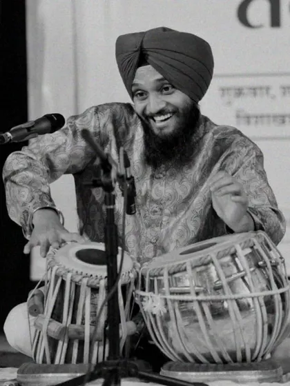 A black and white photograph from a live performance, capturing the joy I feel when I connect with the audience through the bols of the tabla.