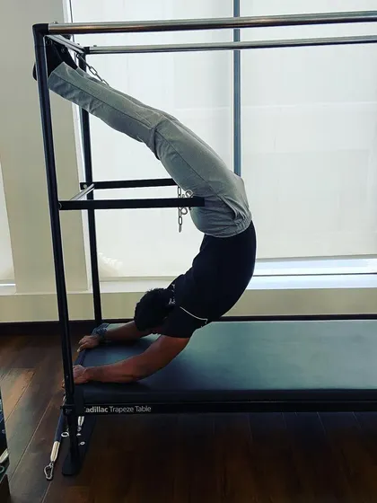 It is better to bend than to break. This deep spinal flexion on the Cadillac Trapeze Table is an advanced move that showcases incredible core stability and flexibility. This is the kind of progress we work towards in my sessions.