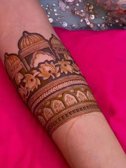 A close-up of an architectural arm band. The design features domes and lotus flowers, perfect for a traditional and royal look.