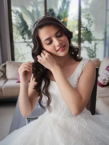 It's all in the details. Crystal putting on her earrings, with her beautifully styled hair and flawless makeup ready for the ceremony.