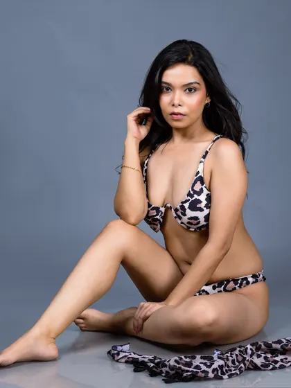 A studio shot of a model in an animal print bikini against a solid grey backdrop. I create clean, professional images for swimwear brands and model lookbooks.