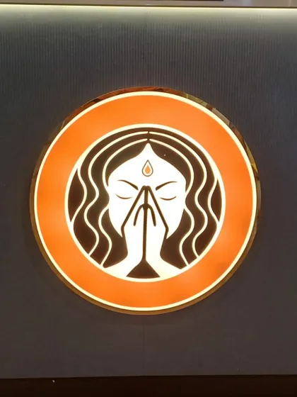 A close-up of my logo. The 'Grihini' with folded hands represents my philosophy of serving food with respect, love, and care.