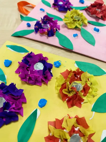 A close-up showing the texture of the crumpled tissue paper flowers and the shiny sequins.