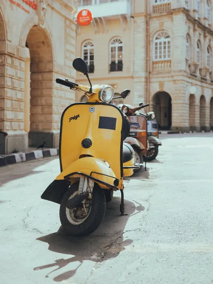 A bright yellow vintage scooter parked on the street. It’s not just cars; I love capturing the design and nostalgia of classic two-wheelers as well.