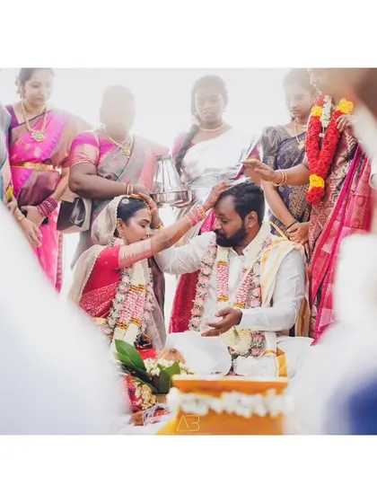 The bride performs a ritual, placing her hand on the groom's head. It's these small, significant gestures that I look for to tell the complete story of a wedding day.